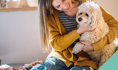 A lady cuddling a dog on her lap