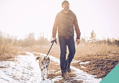 A man walking a dog outdoors